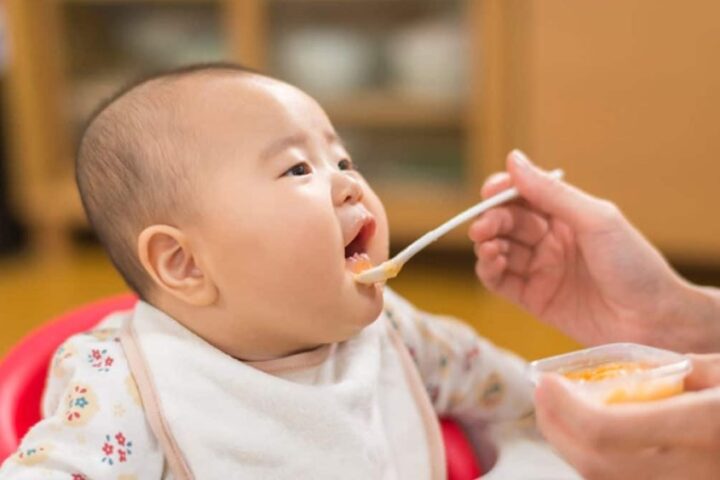 Em bé đang ăn, minh họa thời điểm thích hợp để mẹ áp dụng cách nấu thịt cho bé ăn dặm từ thịt bò.