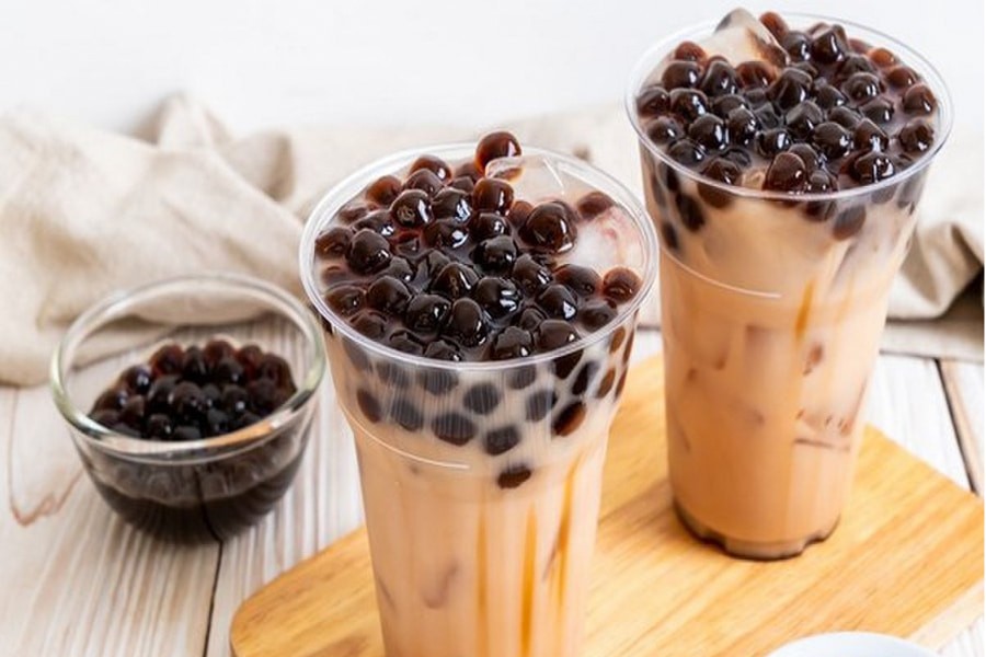 Một ly trà sữa truyền thống với trân châu đen và lá bạc hà trang trí, thể hiện hương vị đặc trưng của món đồ uống nổi tiếng